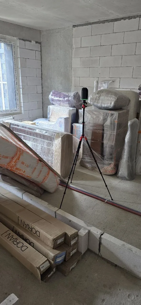 Measuring equipment on a tripod in a flat under construction